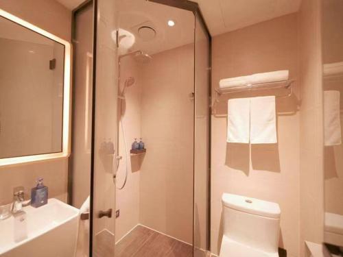 a bathroom with a shower and a toilet and a sink at Hanting Hotel Beijing Huilongguan Subway Station in Beijing