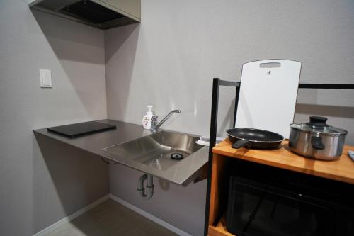 a kitchen with a sink and a pot on a counter at Etcetera Niijima Nagisa Building - Vacation STAY 41900v in Niijimamura
