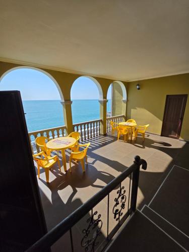 a balcony with tables and chairs and the ocean at Sunny Beach Hotel in K'obulet'i