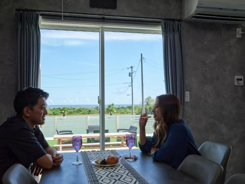 a man and woman sitting at a table with wine glasses at VOGUE C, a private inn with a panoramic view of th - Vacation STAY 14693v in Isumi