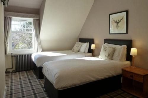 a bedroom with two beds and a window at Camus House, Lochside Guest House in Onich