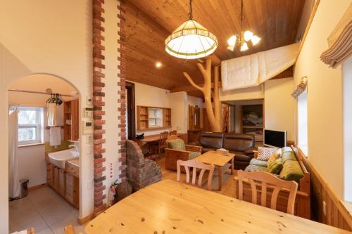 a living room and a kitchen with a couch and a table at Yubari Shikanotani residence - Vacation STAY 16529 in Yubari