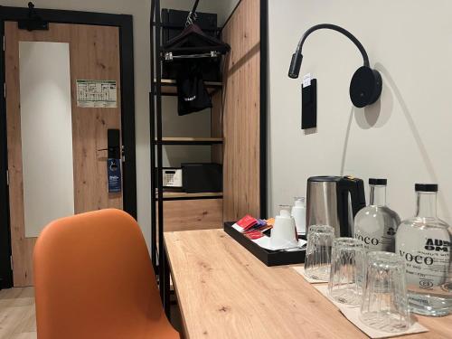 a desk with a chair and a table with glasses at voco Bilbao - City by IHG in Bilbao