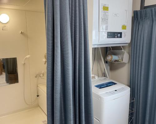a bathroom with a blue curtain and a washing machine at THE CABIN KAMAKURA - Vacation STAY 20235v in Kamakura