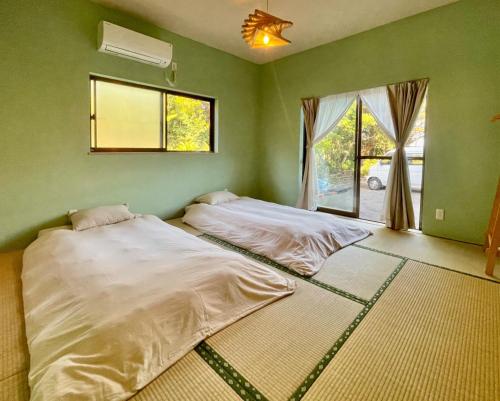 two beds in a green room with a window at Yoronto - Vacation STAY 18850v in Yoron