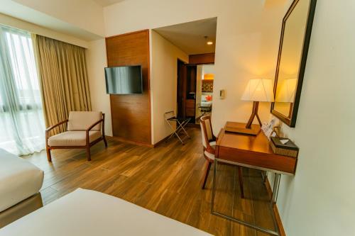 a hotel room with a desk and a bedroom at Best Western Plus The Ivywall Resort-Panglao in Panglao