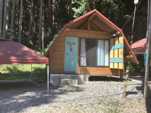 a small house with a blue door in a yard at Nakano-san Chi Campsite & RV Park Hotaru no Sato- Camp - Vacation STAY 42210v in Higashi-shibuta