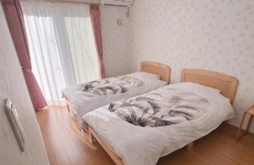 two twin beds in a room with a window at Villa & BBQ grounds Palm Village - Vacation STAY 42254v in Otohama