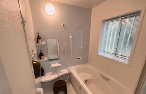 a white bathroom with a tub and a sink at Villa & BBQ grounds Palm Village - Vacation STAY 42254v in Otohama