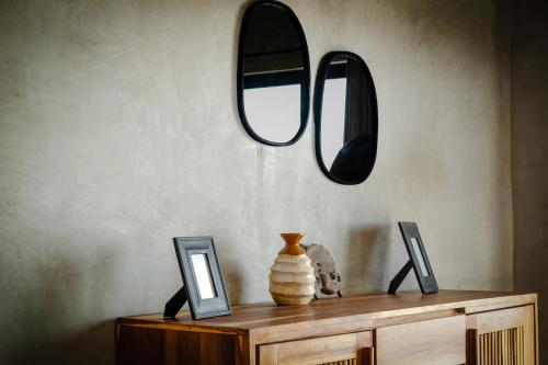 a table with two pictures and a mirror on a wall at MUUN Beach Club in Ciudad del Carmen