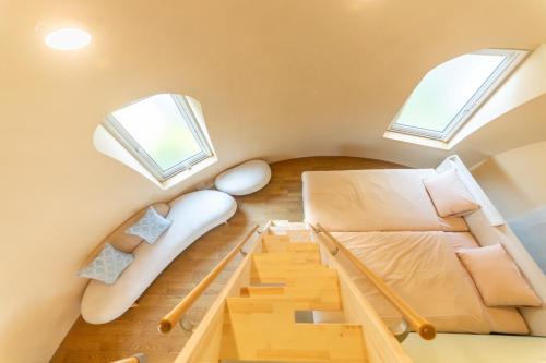 a small attic room with a bed and two windows at Cam Cam Dome House & SAUNA (Toyooka Beach) - Vacation STAY 66776v in Minamiboso
