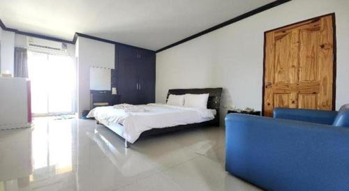 a bedroom with a bed and a blue couch at ONE Residence in Pathum Thani