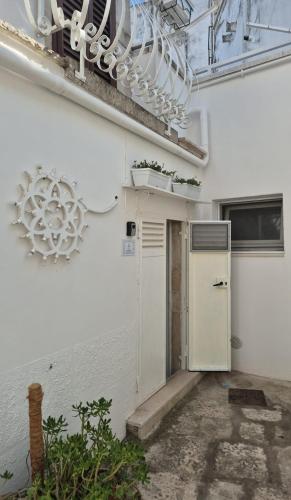 a white building with a refrigerator and a chandelier at Elyan alcova experience in Noci