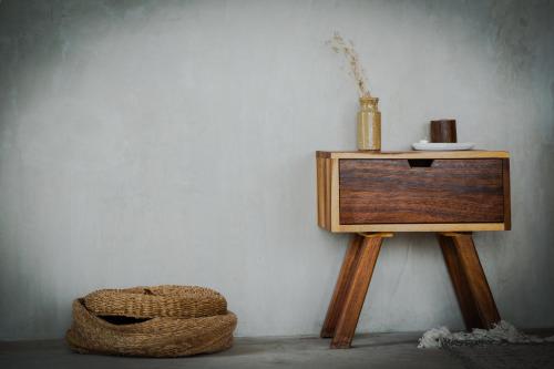 a wooden table with a vase on it next to a wall at MUUN Beach Club in Ciudad del Carmen