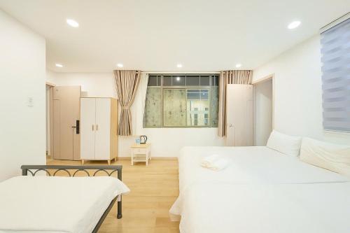 a bedroom with two beds and a window at Lunaria Maison - Thư Thái Homestay in Ho Chi Minh City
