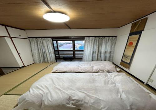 a bedroom with a bed in a room with a window at Ota Apartment - Vacation STAY 17531 in Otaru
