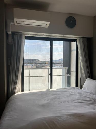 a bedroom with a bed and a large window at REVISION Ebiyama-tei - Vacation STAY 17794 in Hiroshima