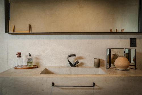 a kitchen counter with a sink and a mirror at MUUN Beach Club in Ciudad del Carmen