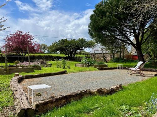 a bench and a table in a garden at De rulinen in Saint-Clet