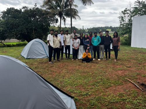a group of people standing next to a tent at Primal Camping in Yelagiri