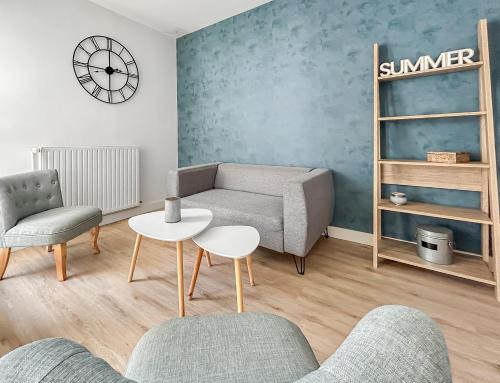 a living room with a couch and a table and chairs at Séjour idéal à Lorient, spacieux T4, ville & mer in Lorient
