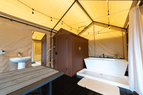 La salle de bains est pourvue d'une tente avec une baignoire et un lavabo. dans l'établissement SPRINGS VILLAGE Ashigara-Tanzawa Hot Spring Resort & Glamping - Vacation STAY 42320v, à Oyama