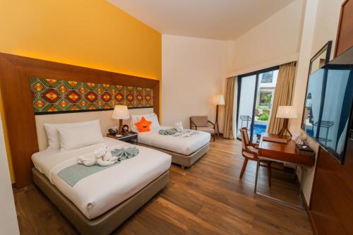 a hotel room with two beds and a flat screen tv at Best Western Plus The Ivywall Resort-Panglao in Panglao