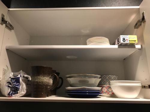 a shelf with bowls and other items on it at Tokurajyo - Vacation STAY 15842 in Akiruno