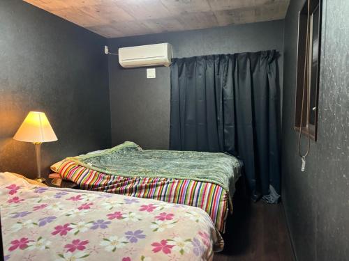 a room with two beds and a lamp and curtains at Tokurajyo - Vacation STAY 15842 in Akiruno