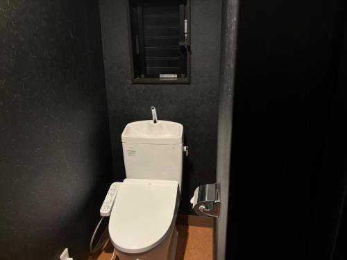 a bathroom with a white toilet in a black wall at Tokurajyo - Vacation STAY 15844 in Akiruno
