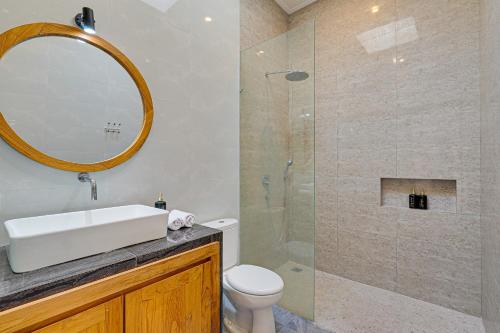 une salle de bain avec un lavabo et une douche avec un miroir dans l'établissement Villa Polo - Padonan near Canggu with Private Pool, à Dalung