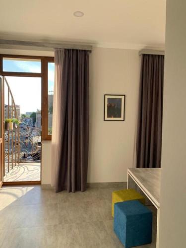 a living room with a table and a window at Hotel Menua in Yerevan