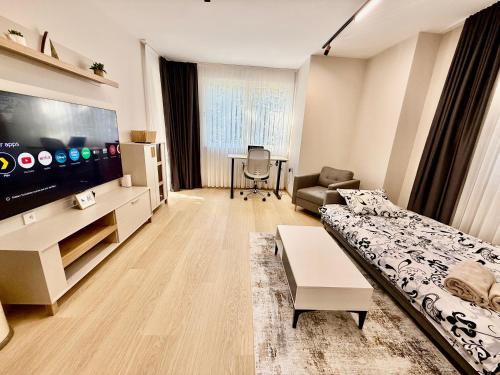 Una sala de estar con un sofá y un televisor de pantalla plana. en Beach Please Apartment, en Burgas