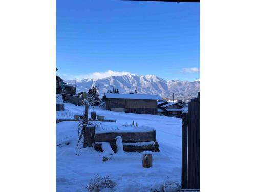 a snow covered village with mountains in the background at LongHillsEcoGuesthouse&Cafe - Vacation STAY 24885v in Kinoshita