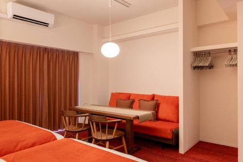 a room with a couch and a table and chairs at Hotel TOKI 季 in Tokyo