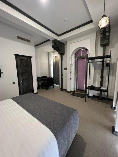 a large bedroom with a bed and a table at Rasoda Hotel&Restaurant in Tashkent