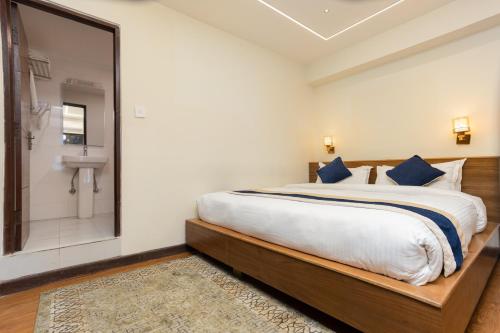 a bedroom with a large bed and a bathroom at Kathmandu Business Hotel in Kathmandu