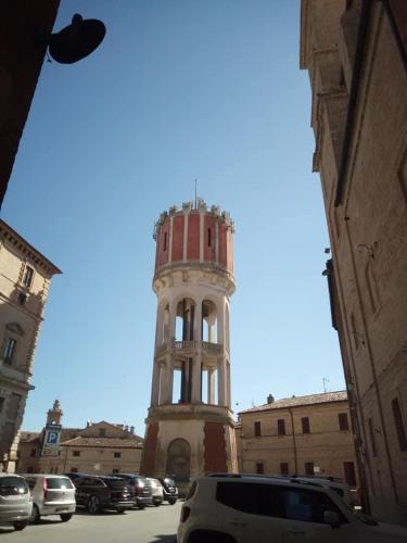 a building with a clock tower in the middle of a street at Affittacamere Flli Rossi in Tornasano