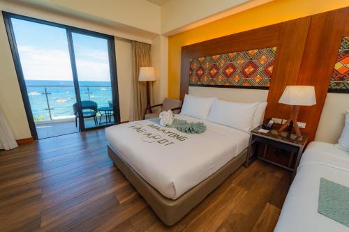 a hotel room with a bed and a view of the ocean at Best Western Plus The Ivywall Resort-Panglao in Panglao