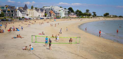 a group of people playing soccer on a beach at Séjour idéal à Lorient, spacieux T4, ville & mer in Lorient