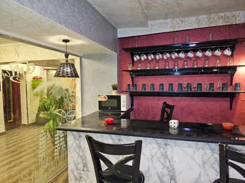 a bar in a restaurant with a red wall at Oasis Heliopolis Hotel-فندق أوازيس هليوبوليس in Cairo