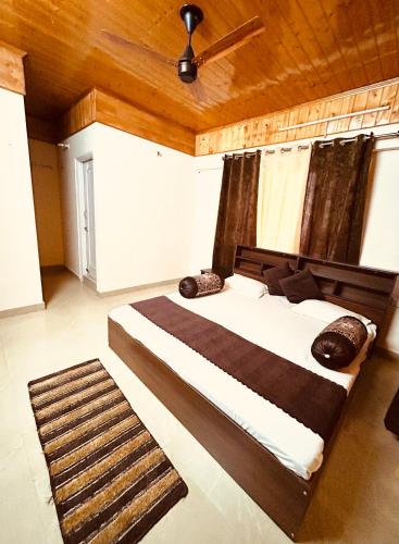 a bedroom with a large bed with a wooden ceiling at Ashiana at Ivy Apartments in Solan