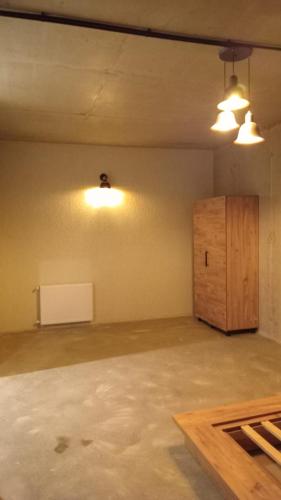 Urekis SadguriにあるIO Houseの2つの照明と木製のキャビネットがある空の部屋