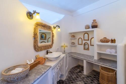 a bathroom with a sink and a mirror at La Santa Rosa in Uluwatu