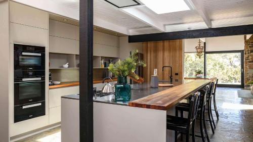 a kitchen with a large island with a wooden counter top at Flow Stone House Gisborne in Gisborne