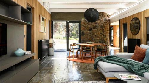 a living room with a couch and a table at Flow Stone House Gisborne in Gisborne