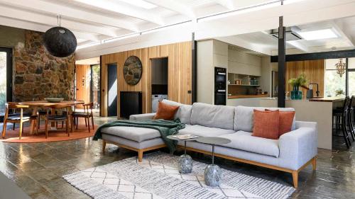 a living room with a couch and a table at Flow Stone House Gisborne in Gisborne