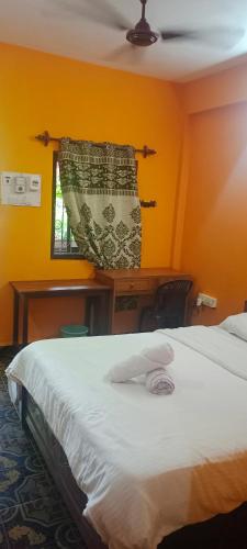 a bedroom with a white bed and a window at selfia guest house in Majorda