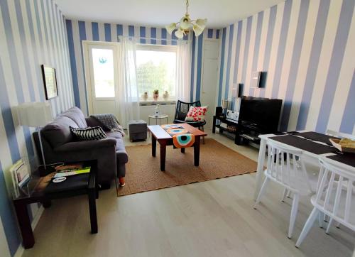 a living room with a couch and a table at Merikarhun kaksio - apartment by the sea, 5 mins off the highway in Kemi