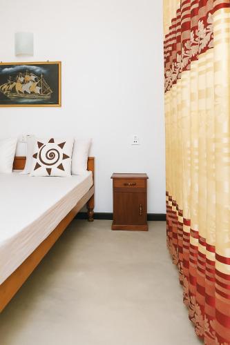 a bedroom with a bed and a curtain at Villa South view Residence in Galle